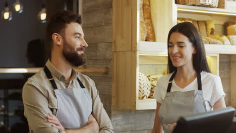 Young-Man-And-Woman-Bread-Sellers-Standing-At-The-Counter-And-Talking-Cheerfully