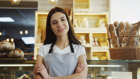 Portrait-Of-The-Pretty-Female-Bakery-Vendor-Standing-At-The-Counter-And-Smiling-To-The-Camera