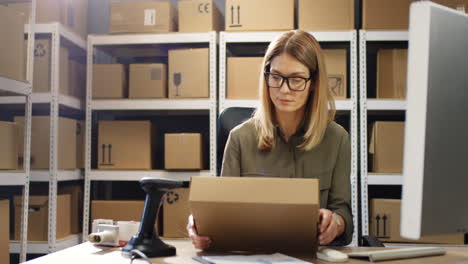 Beautiful-Woman-Post-Worker-Sitting-At-Desk-And-Working-At-Computer-In-Postal-Delivery-Store