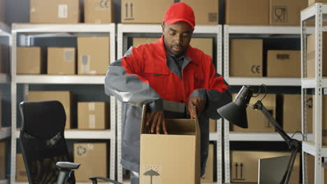 Postangestellter-In-Uniform,-Der-Karton-An-Den-Tisch-Bringt-Und-Paket-In-Der-Zustellabteilung-Im-Postamt-Verpackt