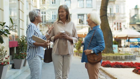Three-Friendly-Good-Looking-Old-Ladies-Standing-In-The-City-And-Talking
