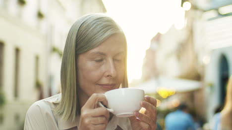 Close-Up-Of-Beautiful-Senior-Woman-Wih-Gray-Hair-Drinking-Coffee-At-Cafe-Outdoor-And-Thinking-Or-Dreaming