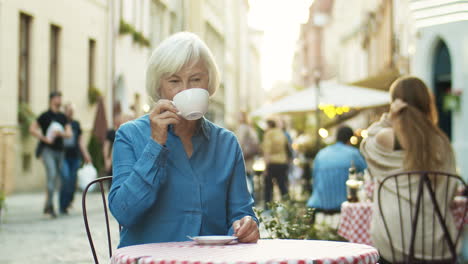 Alte-Schöne-Großmutter-Mit-Grauem-Haar-Trinkt-Kaffee-Und-Ruht-Sich-Im-Café-Im-Freien-Aus