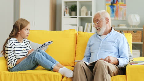Senior-Grey-Haired-Grandpa-Helping-His-Lovely-Teenage-Granddaughter-Doing-Her-Homework