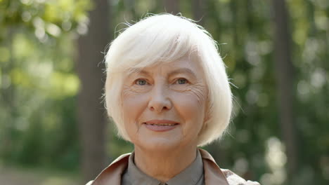 Portrait-Of-Senior-Grey-Haired-Lady-Standing-In-Wood