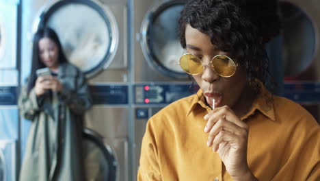Young-Pretty-And-Stylish-Girl-In-Yellow-Glasses-Siting-In-Laundry-Service-Room