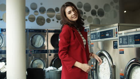 Joyful-Pretty-And-Stylish-Woman-Having-Fun-And-Dancing-In-Laundry-Service-Room-While-Machines-Washing-Working