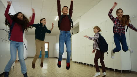 Cheerful-Happy-Kids-Running-The-School-Coridor,-Jumping-And-Having-Fun-After-Teir-Lessons-Or-During-A-Break