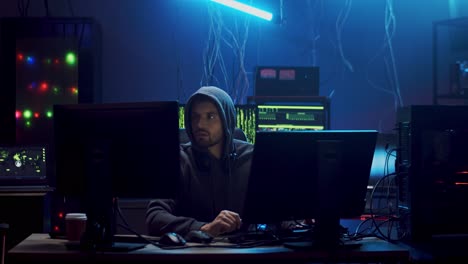 Young-Man-Hacker-Commiting-Cybercrime-While-Hacking-At-Two-Computers-In-The-Dark-Programming-Room-With-Technologies