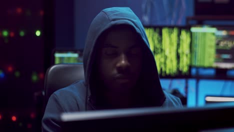 Close-Up-Of-The-Young-Male-Virtual-Spy-In-A-Hood-Hacking-Some-Software-At-Night-In-The-Dark-Room-1