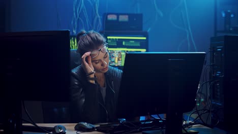 Good-Looking-Young-Woman-In-Glasses,-Software-Developer-Or-Hacker-Working-At-The-Computer-Screen-In-The-Dark-Room-Late-At-Night-And-Being-Very-Tired,-Taking-Off-Glasses-And-Giving-Her-Eyes-A-Rest