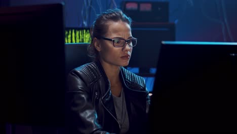 Attractive-Female-Software-Developer-In-Glasses-Working-Over-The-Hacking-Programs-At-The-Dark-Room,-Then-Leaning-On-The-Chair-And-Resting-From-Tensive-Job