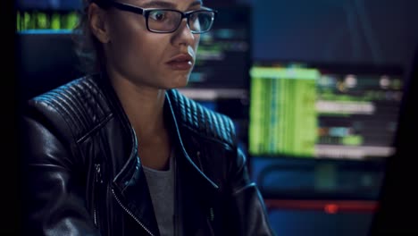 Close-Up-Of-The-Young-Beautiful-Woman-Software-Developer-In-Glasses-Working-Over-The-Computer-Programs-At-The-Dark-Room
