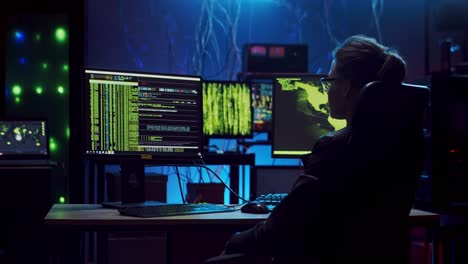Rückansicht-Der-Weiblichen-Softwareentwicklerin-Mit-Brille,-Die-über-Hacking-Programme-Am-Computer-Mit-Codes-Auf-Dem-Bildschirm-Arbeitet-Und-Nachts-Im-Dunklen-Raum-Auf-Einem-Stuhl-Ruht