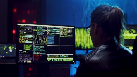 Rear-Of-The-Close-Up-Of-The-Female-Software-Developer-In-Glasses-Working-And-Hacking-Programs-Or-Codes-At-The-Big-Screen-Of-Computer-At-Night