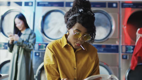 Young-Beautiful-Girl-In-Yellow-Glasses-Sitting-In-Laundry-Service-Room