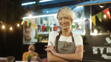 Happy-Pretty-Cheerful-Young-Woman-In-Apron-With-Blond-Short-Hair-Turning-And-Smiling