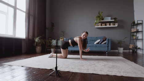 Wide-Shot-Of-An-Exultant-Athletic-Young-Woman-Giving-An-Online-Fitness-Lesson