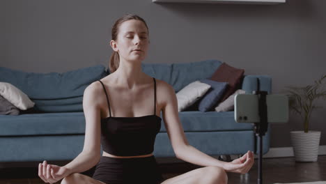 Junge-Schöne-Frau,-Die-In-Lotushaltung-Eine-Yogastunde-Aufnimmt-Und-Intensiv-Atmet