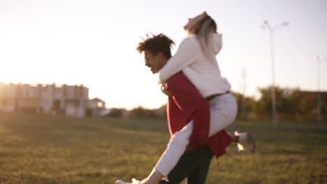 Happy-Young-Men-Giving-Piggyback-Ride-To-Women-In-The-Park