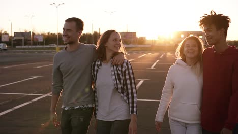 Group-Of-Four-Young-Multirace-Friends-Laughing-While-Walking-Outdoors-1