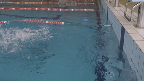 Seitenaufnahme-Einer-Jungen-Schwimmerin-Beginnt-Rückenschwimmen-Im-Hallenbad
