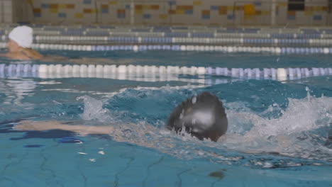 Seitliche-Kamerafahrt-Einer-Jungen-Schwimmerin-Brustschwimmen-Im-Hallenbad