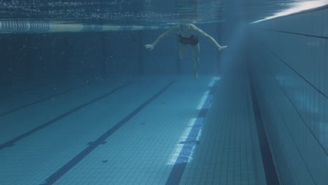Underwater-Shot-Of-A-Young-Female-Swimmer-Crawling-In-An-Indoor-Pool