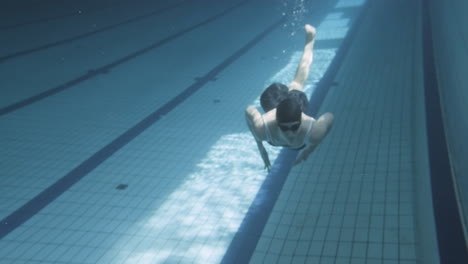 Unterwasseraufnahme-Einer-Jungen-Schwimmerin,-Die-In-Einem-Schwimmbecken-In-Richtung-Der-Kamera-Taucht