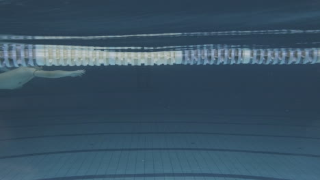 Unterwasser-Seitenaufnahme-Einer-Jungen-Schwimmerin-Mit-Badekappe-Und-Schutzbrille-Im-Hallenbad