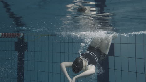Unterwasseraufnahme-Einer-Jungen-Schwimmerin,-Die-An-Den-Rand-Kommt-Und-Sich-Umdreht,-Um-Weiter-Zu-Schwimmen