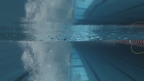 Unterwasseraufnahme-Einer-Jungen-Schwimmerin,-Die-In-Den-Pool-Springt-Und-In-1-Taucht