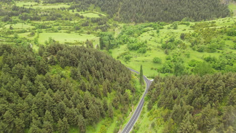Aerial-Drone-View-Of-A-Mountain-Road-In-The-Pyrenees-Leading-Into-A-Beautiful-Valley