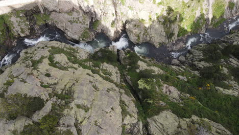 Top-Aerial-Shot-Of-A-Mountain-Gorge-Through-Which-Flows-A-Rushing-River-1