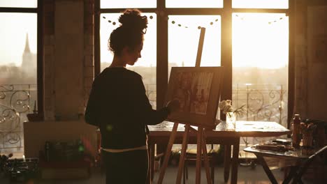 Fully-Concentrated-Sophisticated-Female-Artist-In-Her-20's-Is-Drawing-Picture-On-Easel-In-An-Art-Studio