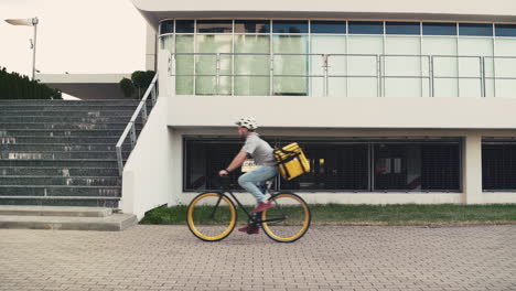 Food-Delivery-Man-Wearing-Thermal-Backpack-Leaves-His-Bike-On-The-Ground-And-Walks-Up-The-Stairs-To-Make-A-Drop-Off