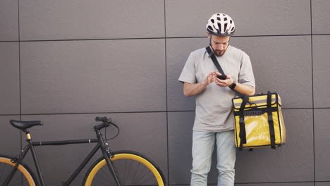 Food-Delivery-Man-With-A-Thermal-Backpack-Consults-An-Order-On-His-Smartphone-1