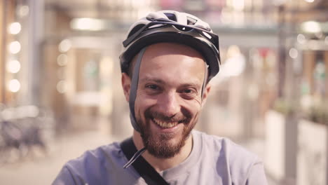 Portrait-Of-A-Smiling-Bearded-Rider-With-A-Helmet-Looking-Directly-At-The-Camera