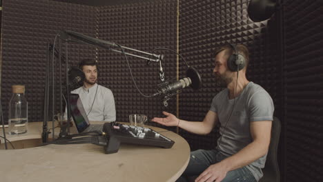 Two-Bearded-Men-Having-A-Funny-Conversation-In-A-Radio-Recording-Studio