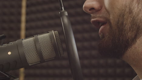 Close-Up-Of-A-Microphone-And-A-Young-Bearded-Man's-Mouth-In-The-Recording-Studio