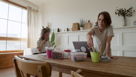 A-Mother-Gives-Her-Daughter-Pencils-So-She-Can-Draw-While-She-Gets-Ready-To-Work-From-Home-On-Her-Laptop