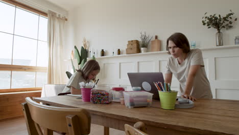 A-Mother-Gives-Her-Blonde-Daughter-Pencils-So-She-Can-Draw-While-She-Gets-Ready-To-Work-From-Home-On-Her-Laptop