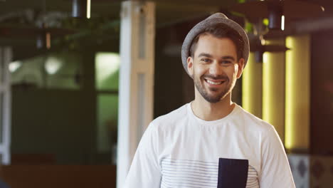Portrait-Of-The-Attractive-Man-Startupper-In-A-Hat-Smiling-To-The-Camera