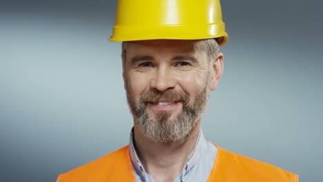 Portrait-Shot-Of-The-Joyful-Male-Builder-And-Architect-In-The-Yellow-Casque-Smiling-To-The-Camera-Happily