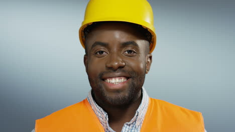 Portrait-Shot-Of-The-Handsome-Young-Man-Builder-In-A-Yellow-Helmet-Turning-Face-And-Smiling-To-The-Camera