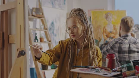 Portrait-Of-Pretty-Stylsih-Hipster-Girl-Artist-With-Dreadlocks-And-In-Glasses