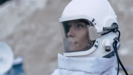 Portrait-Of-A-Female-Astronaut-Wearing-A-Helmet-Looking-Around-Her-On-An-Unknown-Planet