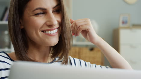 Close-Up-Of-The-Cheerful-Beautiful-Young-Woman-Watching-Something-On-The-Laptop-Computer-And-Smiling-At-Home