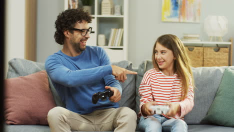 Fröhlicher-Papa-Und-Kleines-Mädchen,-Die-Zu-Hause-Videospiele-Mit-Kontrollen-In-Den-Händen-Spielen