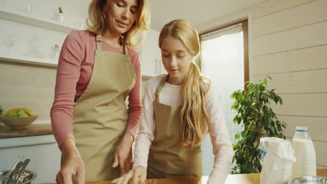 Close-Up-Of-The-Happy-Mother-And-Daughter-Making-A-Pie-And-Rolling-A-Dough-Together-In-The-Nice-Kitchen